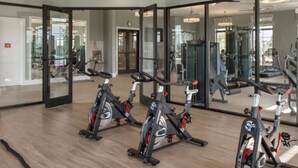 Ein Fitnessraum mit Ergometer, Deckenventilator und einem Ausgangsschild.