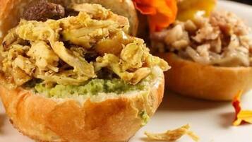 Un sándwich cortado por la mitad, mostrando capas de carne y vegetales en su interior.