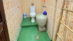 Um banheiro pequeno com vaso sanitário, bidê e uma escada encostada na parede.