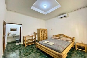 A room with a bed, a desk, and a wardrobe. - Duyung Rooms & Resto Gerupuk (Kuta)