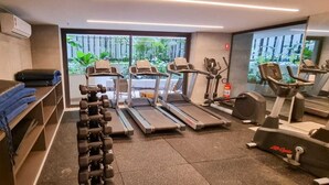 Une salle de sport équipée de tapis de course, d’haltères et d’appareils de musculation.