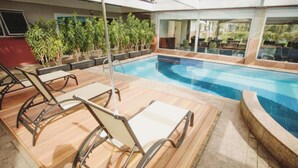 A poolside area with lounge chairs and potted plants.
