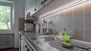 Una cucina moderna con elettrodomestici in acciaio inossidabile, un lavello doppio e una finestra che offre luce naturale.