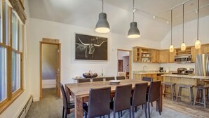 Une cuisine moderne avec des meubles en bois, un îlot central et des luminaires suspendus.