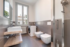 Een douche, een haardroger, een bidet, handdoeken