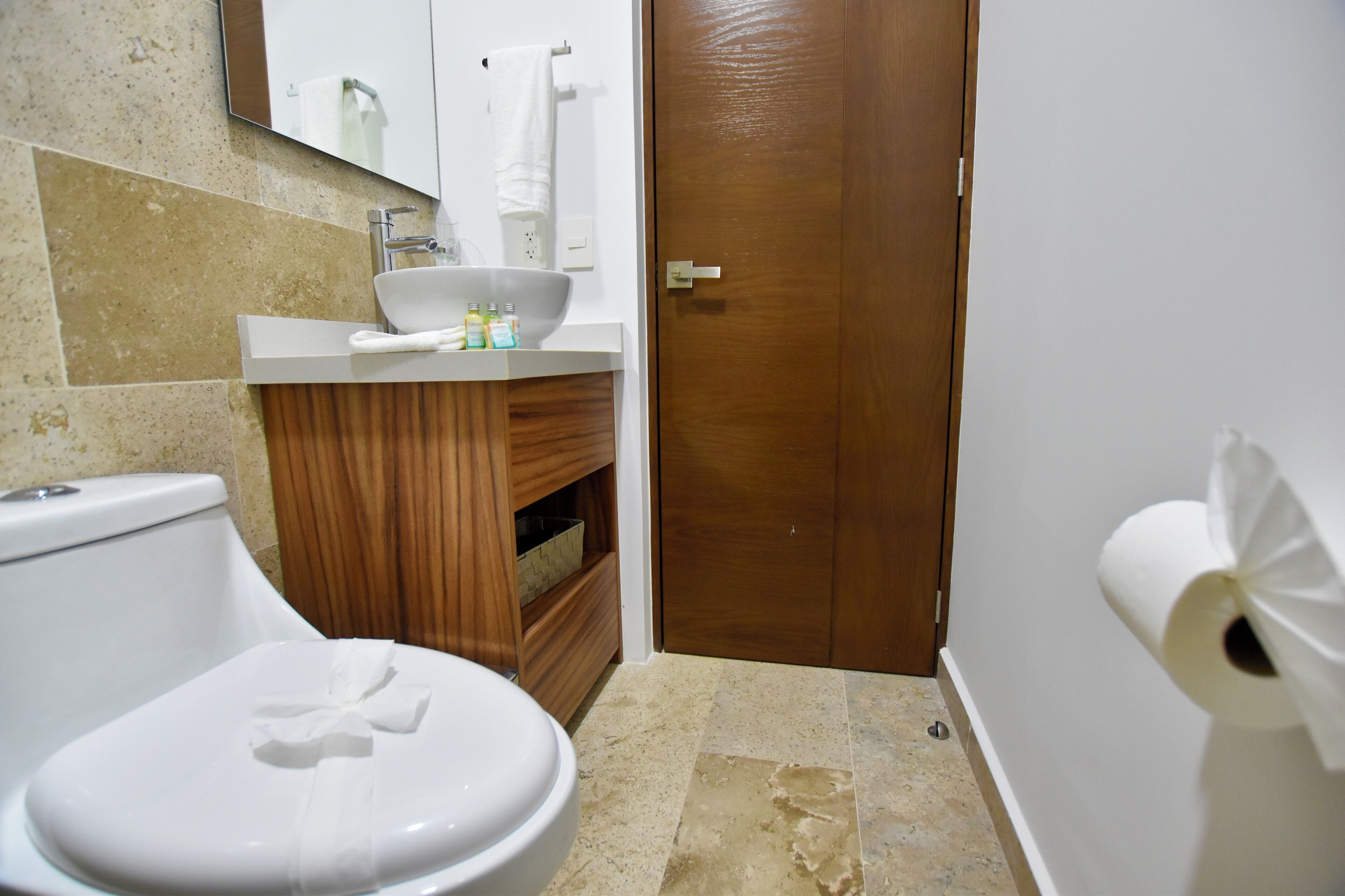 Ein Badezimmer mit Toilette, Waschbecken und einem Holzschrank.
