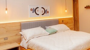 A modern bedroom with a bed, bedside tables, and wall art. - HAB 2 STA MARTA (Santa Marta)