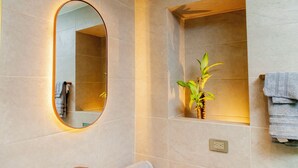 A bathroom with a large oval mirror, a small plant, and a towel rack. - HAB 2 STA MARTA (Santa Marta)
