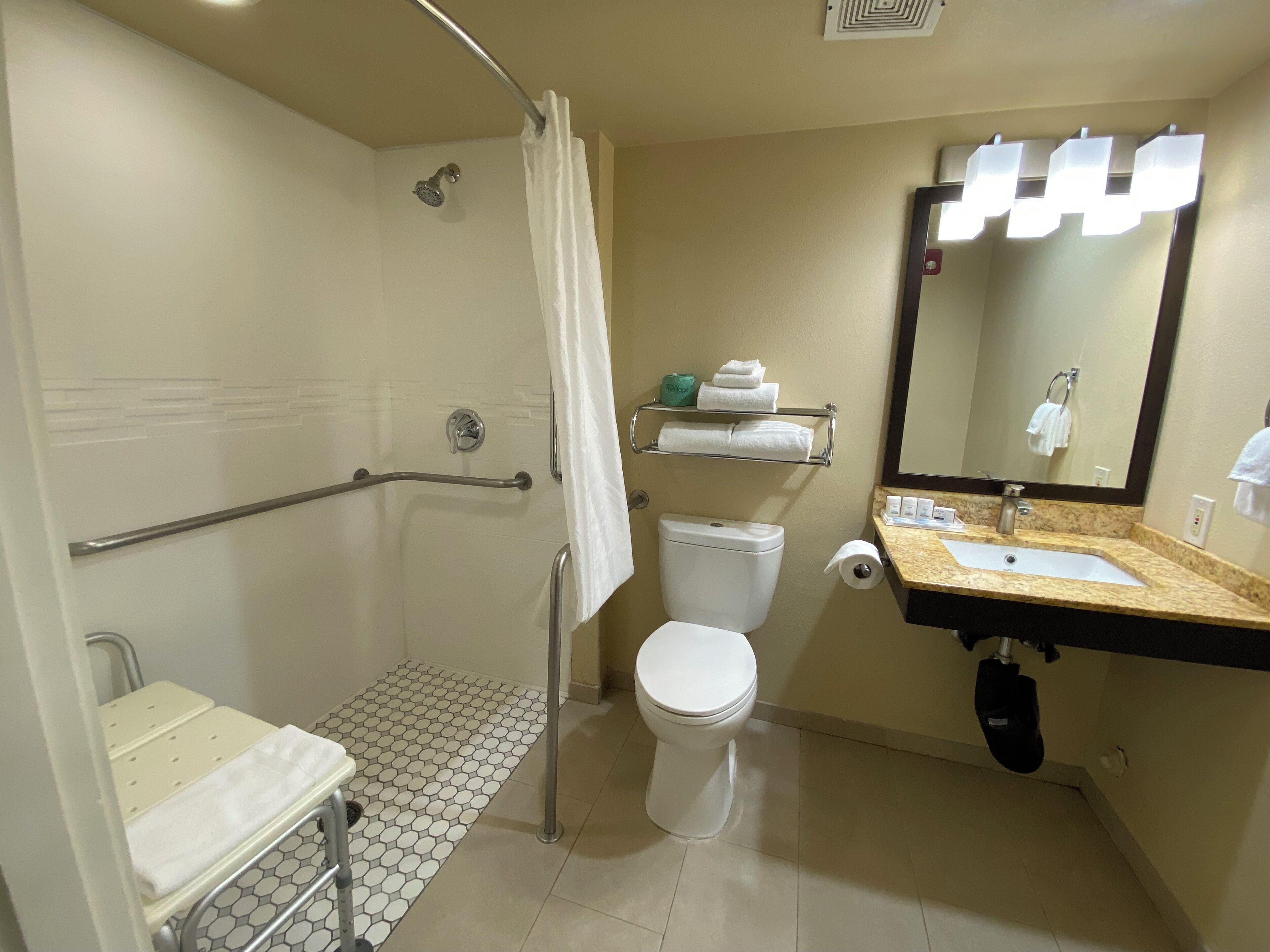 A bathroom with a shower, toilet, and sink.