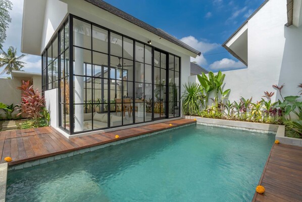A modern house with a glass-enclosed patio and a swimming pool. - Villa Sophian (Ubud)