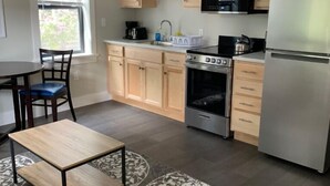 Una cucina moderna con mobili in legno, un frigorifero in acciaio inox, forno integrato e microonde.