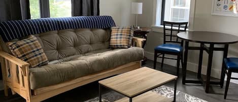 Un salon avec un canapé, une table basse et un tapis à motifs.
