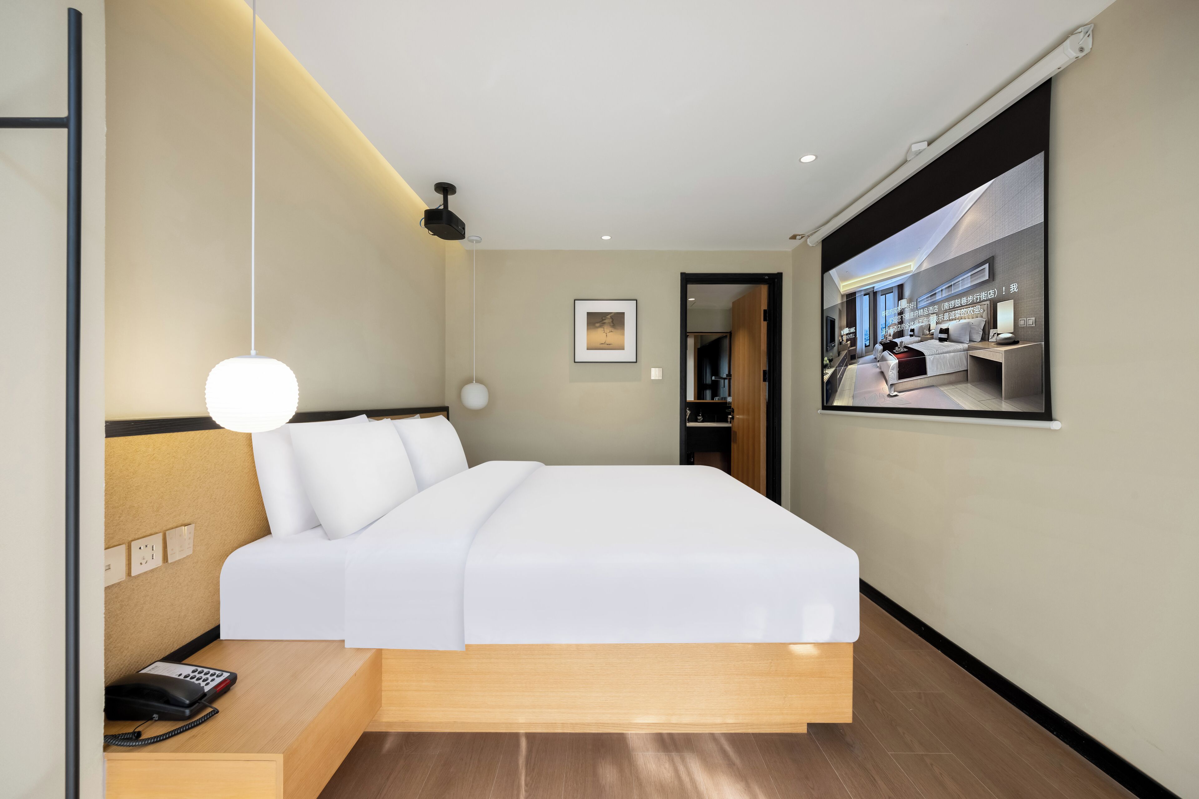 Een moderne hotelkamer met een groot bed, nachtkastje en een tv aan de muur.
