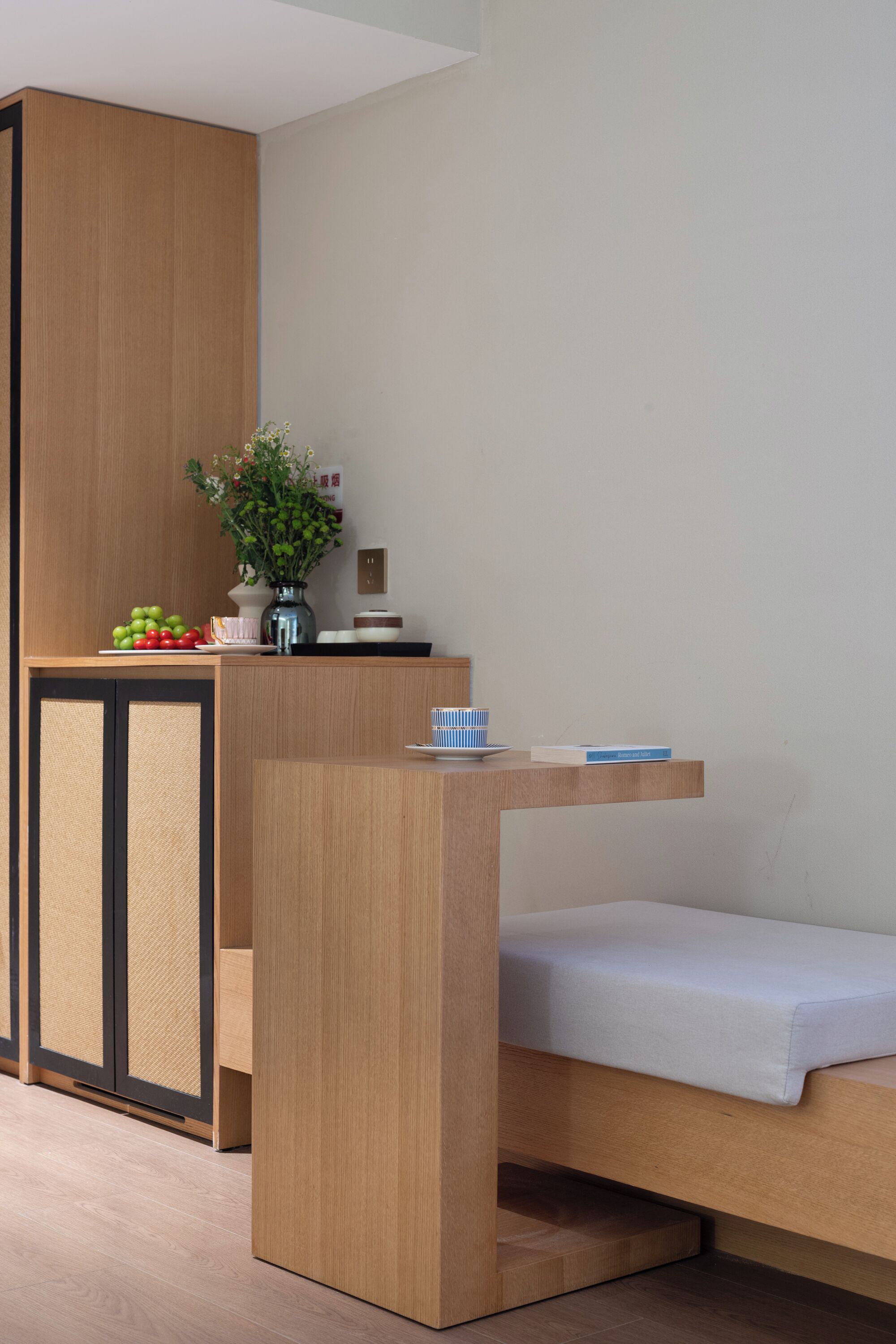 A modern room with a wooden desk, a small bed, and a cabinet.