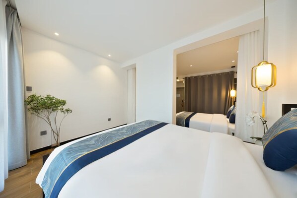A modern hotel room with a large bed, a small plant, and a mirror with a light fixture. - Beijing Aaliyah Wang Fu Jing Forbodden City Boutique Hotel (Beijing)