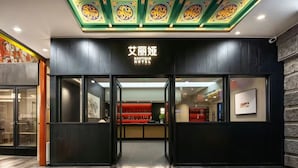 A hotel entrance with a dark facade, glass doors, and a red interior. - Beijing Aaliyah Wang Fu Jing Forbodden City Boutique Hotel (Beijing)