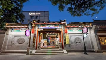 Un edificio tradicional chino con un letrero que dice '艾丽娜 Boutique Hotel' en la entrada.