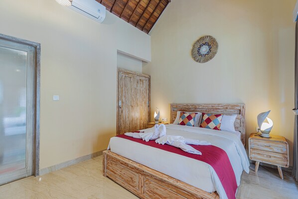 Une chambre à coucher avec un lit en bois, une table de chevet avec une lampe, une décoration murale et une porte.