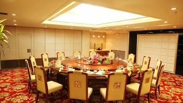 A conference room with a round table, chairs, and a carpeted floor.