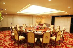 A conference room with a round table, chairs, and a carpeted floor.