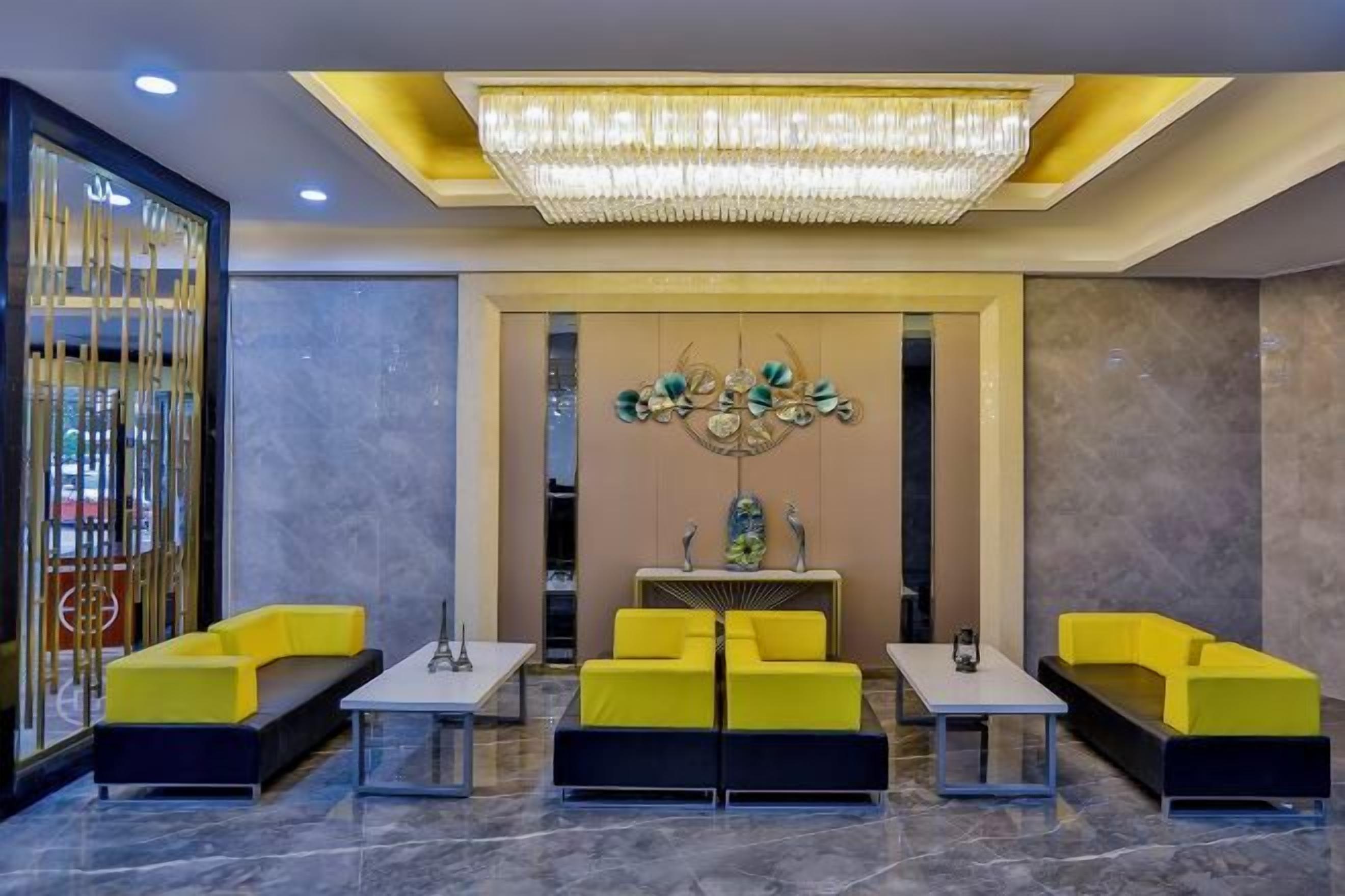 Eine Lobby mit einer Kronleuchter, einer Sitzecke und einem Wandkunstwerk.