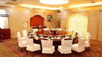 A conference room with a round table, white chairs, and a carpeted floor.