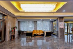 A hotel lobby with a reception desk, seating area, and a large chandelier. - Dushanzi Hotel (Karamay)