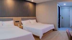 Une chambre d’hôtel avec deux lits, une tête de lit en bois et un mur incurvé orné de lignes verticales.