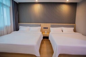 A hotel room with two beds, a wooden headboard, a nightstand, and a window with curtains. - Dushanzi Hotel (Karamay)