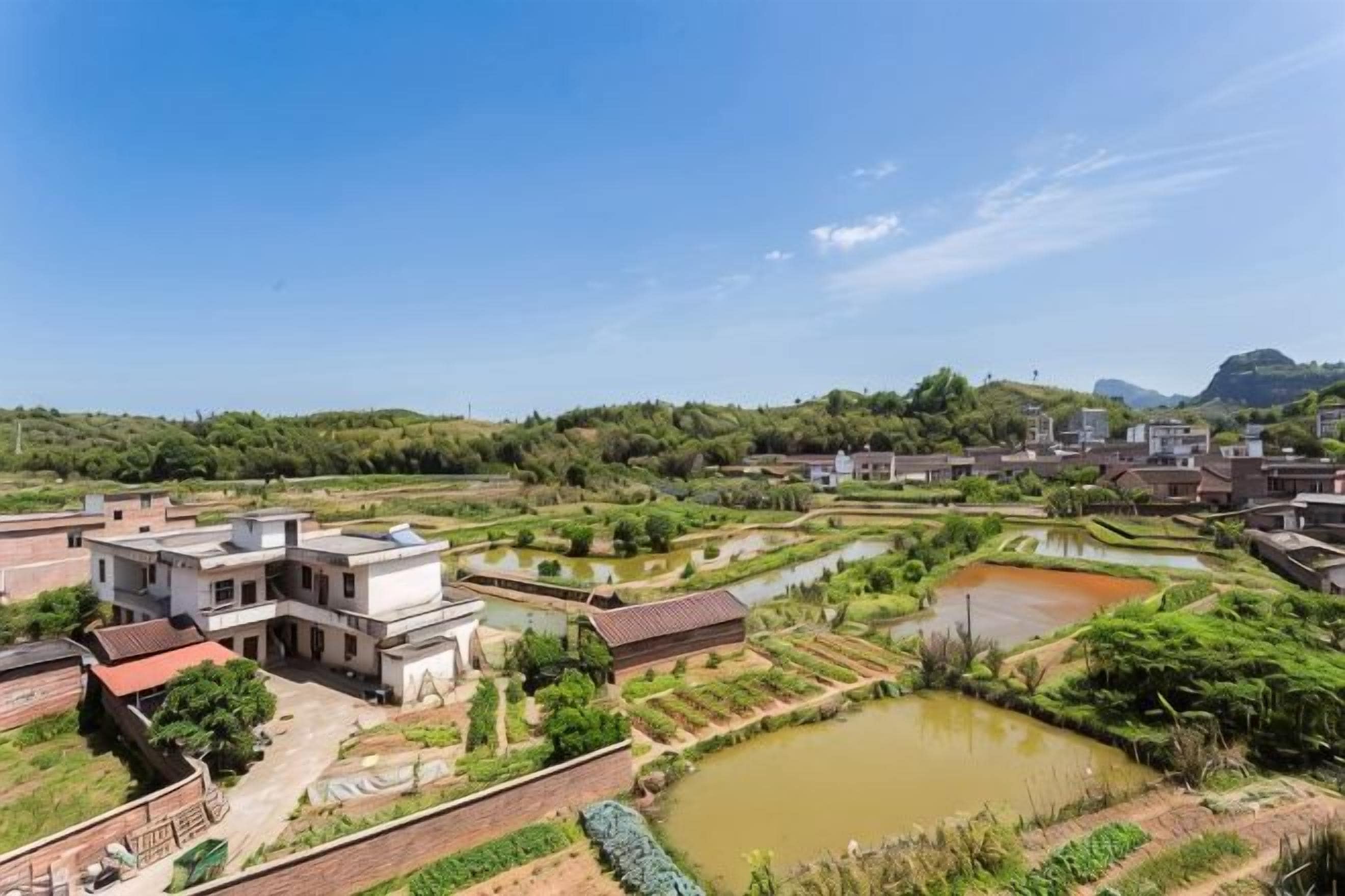 A rural landscape with terraced fields and a building complex.