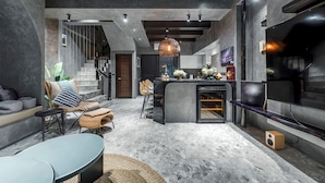 A modern living room with a sofa, chairs, a coffee table, a fireplace, and a TV. - Rolling Hills (Puli)