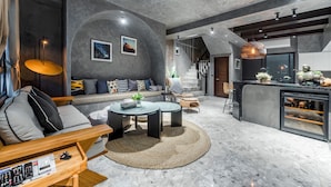 A modern living room with a sofa, coffee table, and a dining area with a bar. - Rolling Hills (Puli)