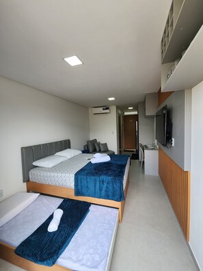 Une chambre d’hôtel avec deux lits, une télévision et une kitchenette.