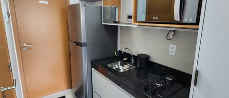 Une cuisine moderne équipée d’un réfrigérateur, d’une cuisinière et d’un four à micro-ondes.