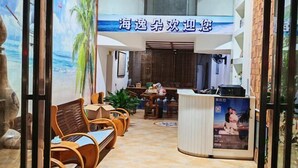 A reception area with a reception desk, seating area with chairs, a wall mural, and a tiled floor. - Beihai Yuhai Elegant Restaurant Hotel (Beihai International Passenger Transport Terminal) (Beihai)