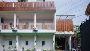 A two-story building with a white facade, a balcony on the upper floor, and a covered entrance. - RedDoorz Syariah near RSUD Mataram Lombok 2 (Mataram)