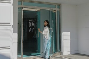 Entrada de un hotel con puerta de vidrio y un letrero que dice "HOTEL OH Air".