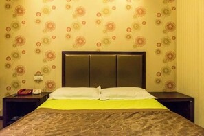 A hotel room with a bed, a nightstand, a telephone, and a wall with a floral pattern. - Xiangyun Yazhi Fashion Hotel (Harbin)