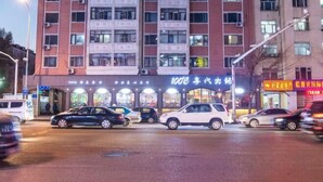 Un edifici de diverses plantes amb diverses botigues a la planta baixa, incloent-hi un restaurant ben il·luminat.