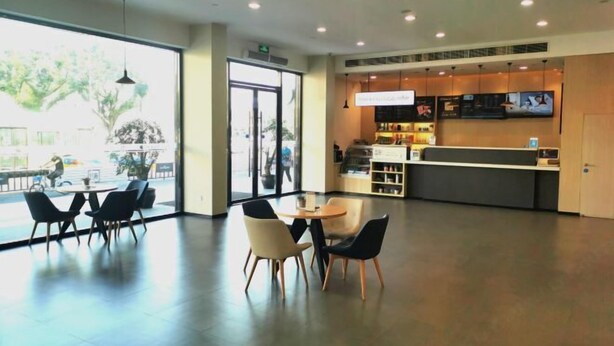 A modern interior with a reception desk, seating area, and large windows. - HanTing Hotel (Rui'an Wansong Road) (Rui'an)