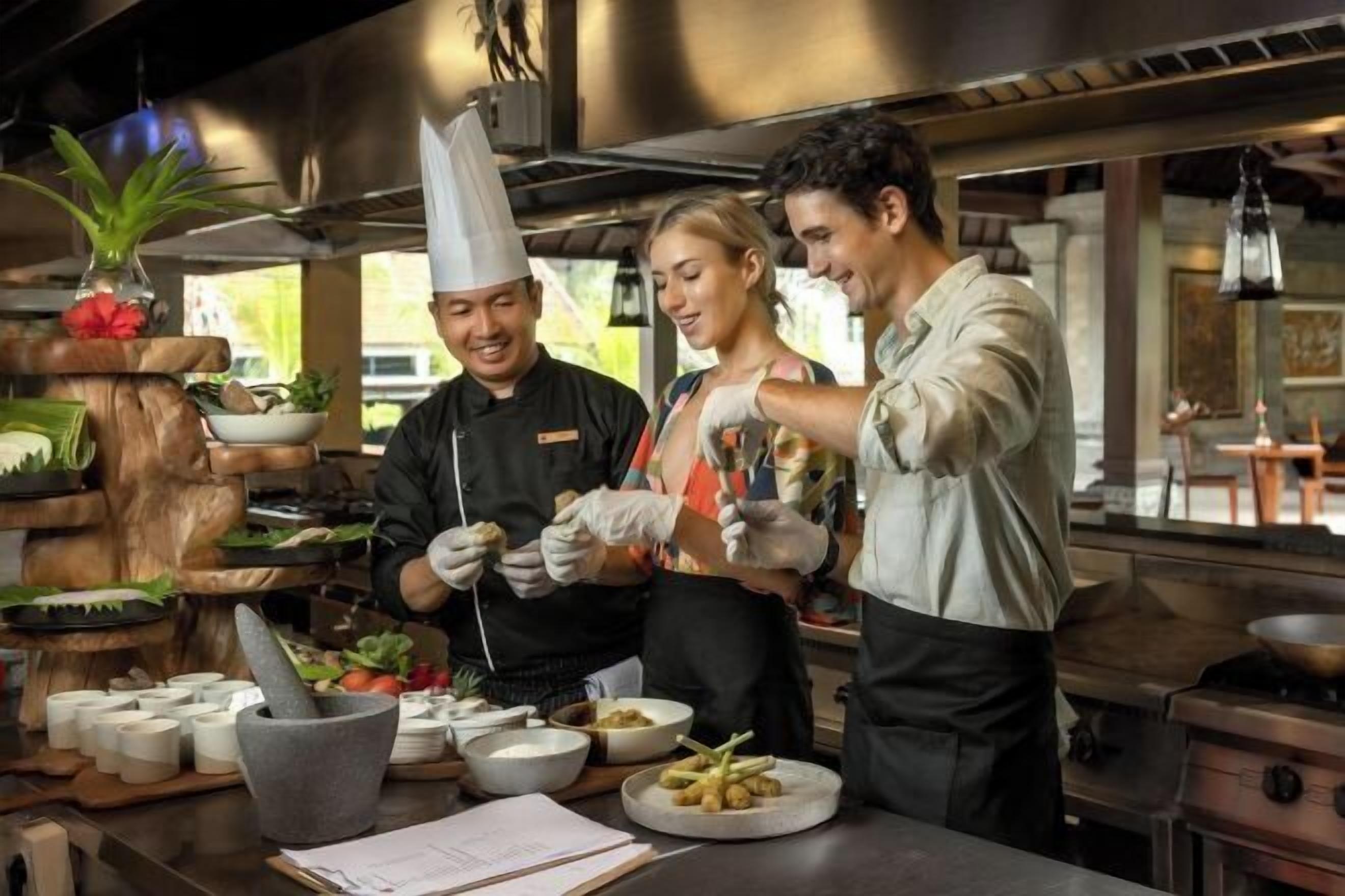 Een kok bereidt eten in een keuken met een rustieke houten toonbank, een vijzel en stamper, en diverse keukengerei.