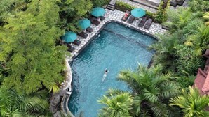 An aerial view of a rectangular pool surrounded by lush greenery and stone tiles. - Sakti Garden Resort & Spa (Ubud)