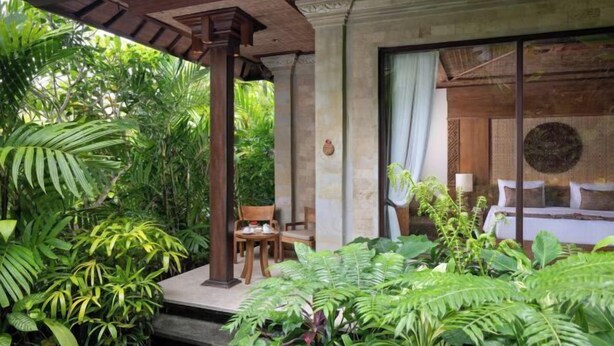 A covered outdoor area with a wooden pergola, a stone bench, and lush greenery. - Sakti Garden Resort & Spa (Ubud)