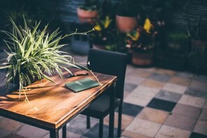 A wooden table with a potted plant and a notebook. - Mambo Boutique Hotel (Pingtung)