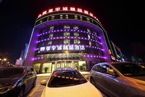 Un hôtel doté d’une façade incurvée et d’une enseigne lumineuse.