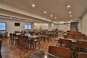 A spacious dining area with multiple tables and chairs, a flat-screen TV mounted on the wall, and a large window providing natural light. - Siji Yucheng Boutique Hotel (Anji Jiuzhou Shopping Mall) (Anji)