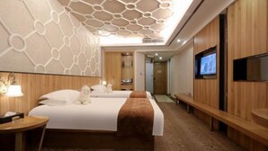 A hotel room with a large bed, a TV, a wooden bench, and a desk with a lamp. - Siji Yucheng Boutique Hotel (Anji Jiuzhou Shopping Mall) (Anji)