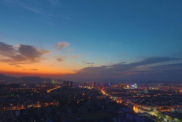 A cityscape at dusk with illuminated buildings and a winding road. - Siji Yucheng Boutique Hotel (Anji Jiuzhou Shopping Mall) (Anji)