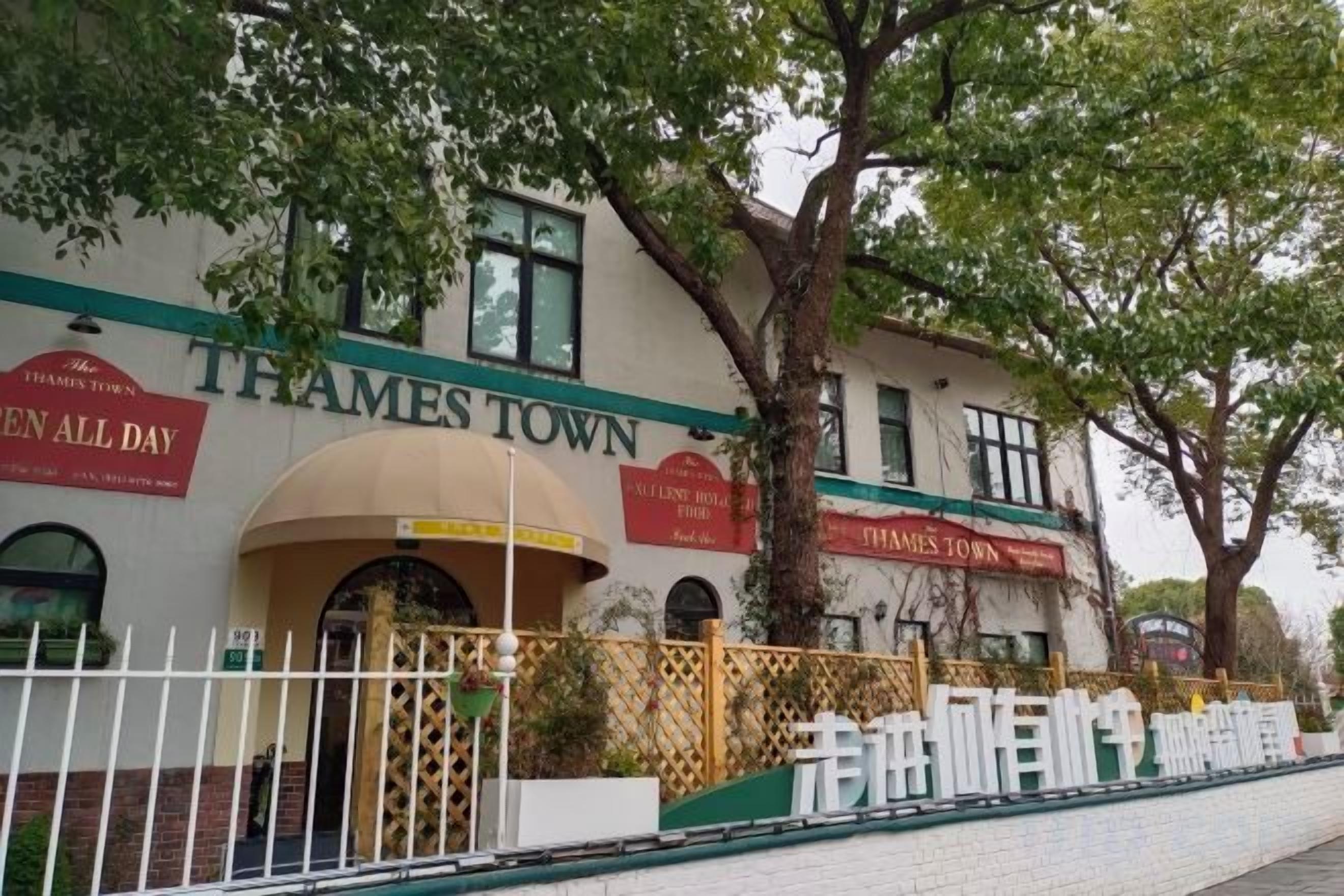 A building with 'Thames Town' signage, a prominent entrance, and a fenced area.