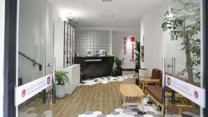 A reception area with a reception desk, seating, and potted plants. - Heyou Cisheng Life Class Health Resort Hotel (Shanghai)